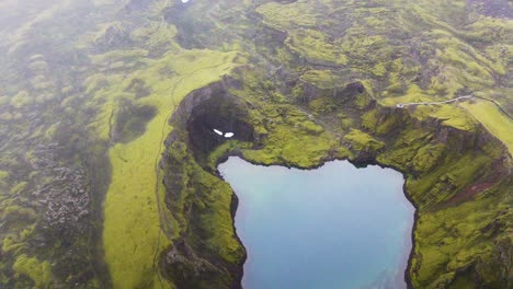 Vista-Pintoresca-De-Tjarnargigur,-Cráter-De-Estanque-Con-Reflejos-Del-Exuberante-Musgo-Verde-En-Lakagigar,-Islandia