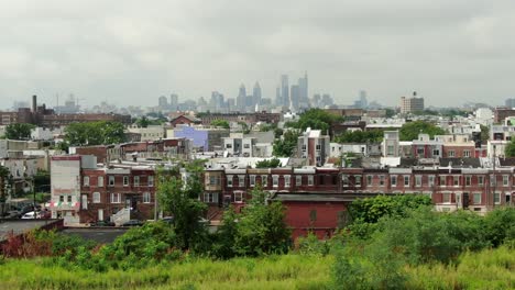 Kensington-North-Philadelphia,-railroad-tracks,-urban-homes-in-poor-community-known-for-crime-and-drug-abuse,-Philly-skyline-in-distance,-aerial-summer-daytime-shot