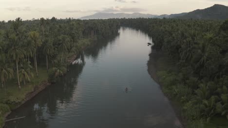 Barco-De-Pesca-Local-Navegando-En-El-Tranquilo-Arroyo-De-Agua-Con-Reflejos-De-Bosque-De-árboles-Verdes-Durante-La-Madrugada-En-La-Provincia-Insular-De-Filipinas