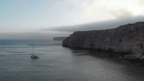 Un-Barco-Solitario-En-El-Mar-Gris-Y-Tranquilo-Al-Atardecer