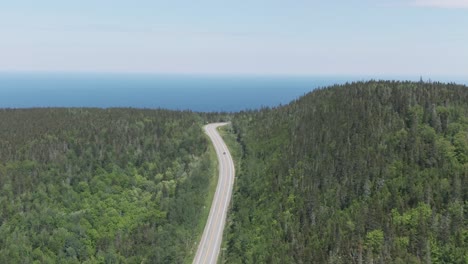 Aerial-shot-of-highway-and-forest-near-Sainte-Anne-Des-Monts-Quebec