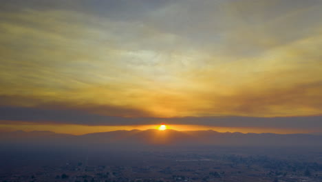 Dunstige-Luftüberblendung-Des-Sonnenuntergangs-über-Der-Wüstenlandschaft,-Die-Vom-Rauch-Des-Seefeuers-In-Südkalifornien-Bedeckt-Ist