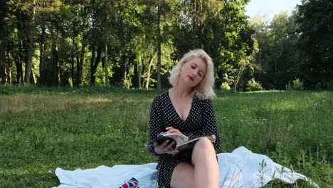A-girl-in-the-park-sits-and-flips-through-a-magazine