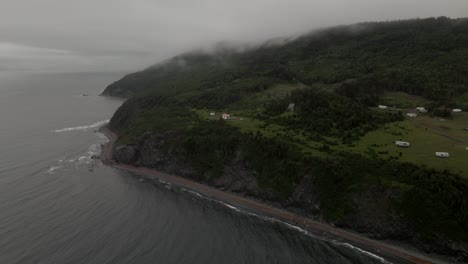 Spectacular-Moody-Drone-Orbit-of-a-Green-Tree-Covered-Coastline-on-a-Cold-Overcast-Foggy-Day