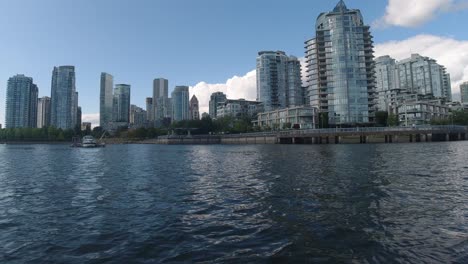 Aerial-Low-fly-by-just-1-feet-above-the-water-thru-False-Creek-BC-Vancouvers-private-yacht-parking-for-the-elite-few-at-the-most-expensive-housing-building-by-the-water-pier-passing-parked-boat