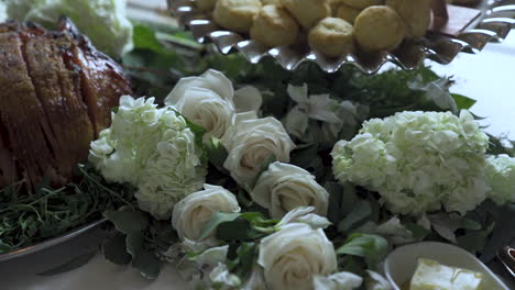 Flowers-laid-out-between-dishes-of-food-at-wedding-party