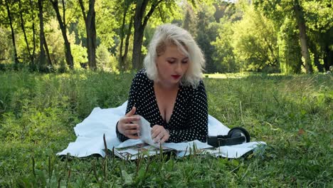 Beautiful-blonde-in-the-woods-flips-through-a-magazine
