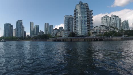 Aerial-Low-fly-by-just-1-feet-above-the-sea-level-thru-False-Creek-BC-Vancouvers-Canada-private-yacht-parking-for-the-elite-few-at-the-most-expensive-highrise-housing-buildings-by-the-harbor-pier
