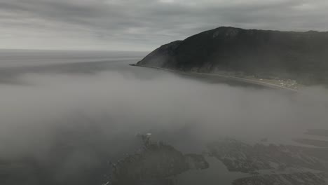 Epic-Drone-Aerial-Flying-through-Fog-on-Overcast-Day-Revealing-Mountains-and-Atlantic-Ocean-Coastline-of-Chic-Chocs-Villlage,-Gaspesie