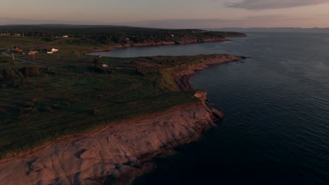 A-Breathtaking-View-Of-Rocky-Cliffs-And-The-Lush-Green-Meadow-Of-Pointe-St-Pierre-During-Sunrise-In-Quebec,-Canada