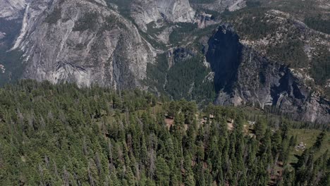 Aerial-reverse-pull-back-and-tilting-up-shot-of-Yosemite-Valley-from-Glacier-Point
