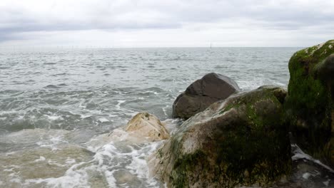 Ocean-tide-waves-splashing-wild-overcast-coastal-rocky-shoreline-seascape