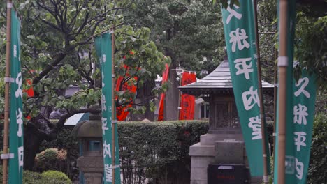 Calm-scenery-inside-Japanese-temple-with-typical-flags-with-writings-and-stone-pillars