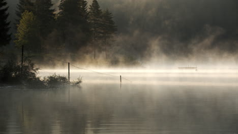 Eerie-Mist-Surrounding-Lake-At-Dusk-In-Switzerland---panning-shot