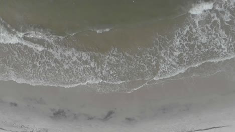 Vacation-concept-top-down-aerial-view-on-gentle-waves-on-empty-beach
