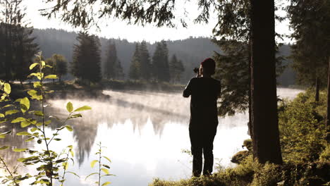 Landscape-Photographer-Taking-Pictures-At-Lake-Caumasee,-Switzerland-On-A-Misty-Morning