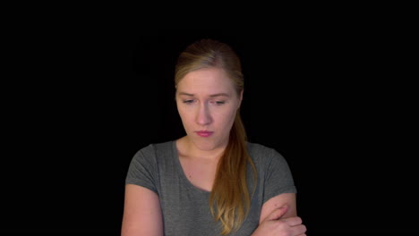Sad-woman-stands-on-black-background-in-slowmotion