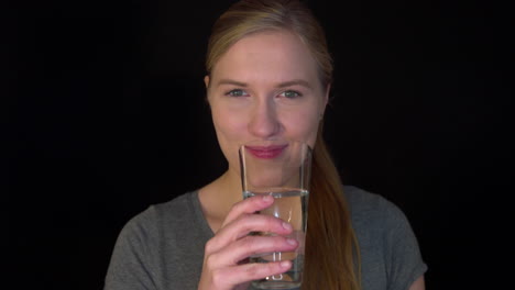 Junge-Frau-Trinkt-Sauberes-Frisches-Wasser-Aus-Glas,-Das-In-Ihrer-Hand-Hält