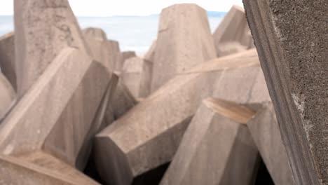 Concrete-formed-coastline-defence-geometric-shape-engineering-on-shoreline-dolly-left-reveal