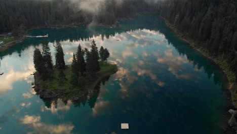 Reflejos-Perfectos-Del-Cielo-Azul-Y-Las-Nubes-En-El-Lago-Caumasee-Que-Rodea-El-Bosque-Verde-Durante-El-Verano-En-Los-Grisones,-Suiza