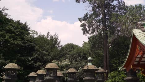 Typische-Japanische-Steinsäulen-Und-Rotes-Schreingebäude-Im-Japanischen-Tempel-Gegen-Blauen-Himmel-Mit-Wolken