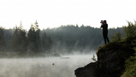 Photographer-Taking-Pictures-Of-Scenic-View-In-Caumasee-Switzerland-At-The-Edge-Of-A-Hill---wide-shot