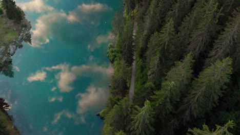 Sky-Reflections-In-The-Clear-Blue-Lake-At-The-Edge-Of-A-Forest-In-Caumasee-Switzerland---aerial-shot