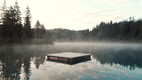 Panoramic-View-Forest-And-Beautiful-Reflection-Of-Sky-And-Trees-In-Caumasee-Lake-On-A-Foggy-Day---drone-shot