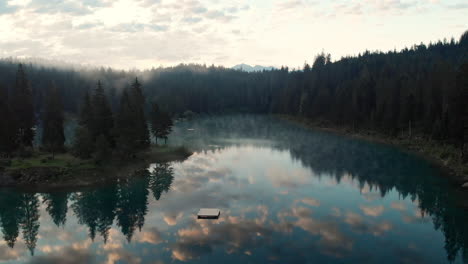Beautiful-Reflection-Of-A-Lush-Forest-Surrounding-Lake---aerial-shot