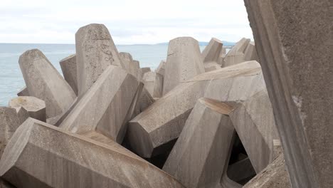 Concrete-formed-coastline-defence-geometric-shape-engineering-on-shoreline-right-dolly-slow