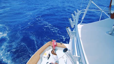 Reveal-pan-of-people-on-lower-deck-of-yacht-on-Caribbean-Sea,-seen-from-above