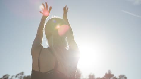 SLOW-MOTION-back-view-of-blonde-woman-doing-yoga-outside-in-strong-sunlight