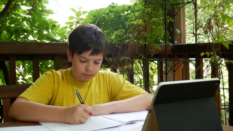 Boy-doing-homework-on-the-balcony