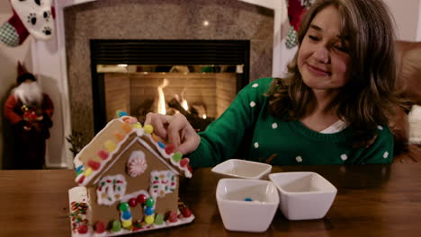 Attractive-Woman-Decorating-Christmas-Gingerbread-House