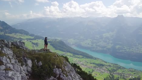 Droneshot-around-a-young-asian-woman-who-stands-on-top-of-a-Mountain-in-Switzerland