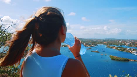 Mädchen-Wanderer-Trinkwasserflasche-Beim-Bewundern-Eines-Hafens-In-Curaçao,-Karibik