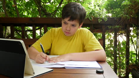 Boy-doing-homework-on-the-balcony