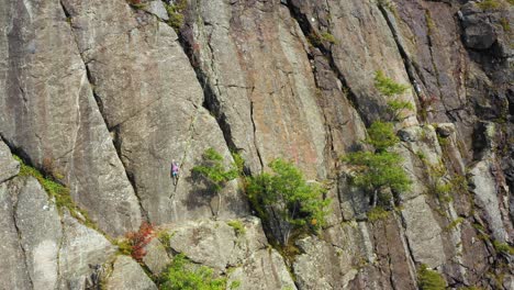 Aerial-footage-PUSH-in-on-young-female-climber-on-cliff-in-Maine