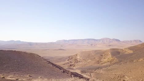 Paisaje-Desértico-Sobre-El-Cráter-Mitzpe-Ramon-En-El-Negev-Fly-By-02
