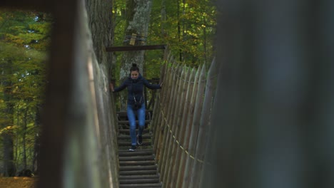 Mädchen-Klettert-Am-Sonnigen-Herbsttag-über-Die-Seilbrücke