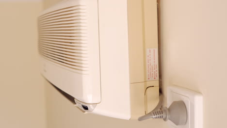 Side-view-of-a-wall-mounted-air-conditioner-being-turned-off