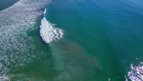 Luftaufnahmen-Von-Wellen,-Die-In-Türkisfarbenem-Wasser-Vor-Der-Pazifikküste-An-Die-Küste-Rollen