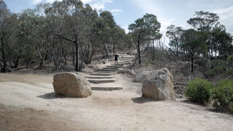 Hombre-Corriendo-Desde-La-Cumbre,-Pico-Flinders,-Parque-Nacional-You-Yangs,-Victoria-Australia
