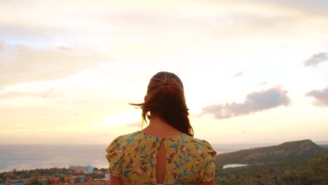 Pedestal-of-an-attractive-woman-in-a-yellow-dress-looking-to-the-sunrise