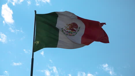Mexican-flag-waving-in-a-blue-sky