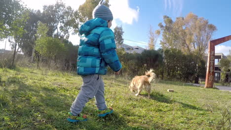 Kid-Running-in-a-Field-With-A-dog-Wide-Shot