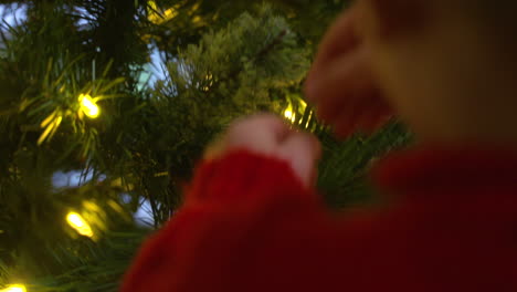 über-Die-Schulter-Eines-Kleinen-Jungen,-Der-Eine-Verzierung-An-Einem-Weihnachtsbaum-Anbringt