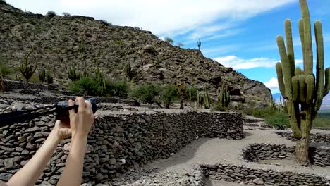 Slow-panning-clip-of-a-young-woman-taking-photos-of-the-Quilmes-Ruins-in-Argentina