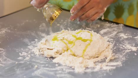 Pouring-olive-oil-over-dough