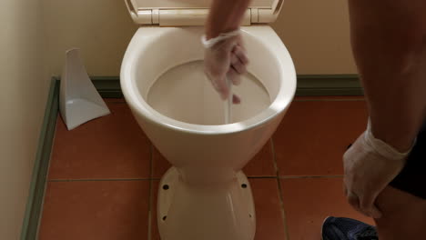 Man-cleaning-household-toilet-bowl